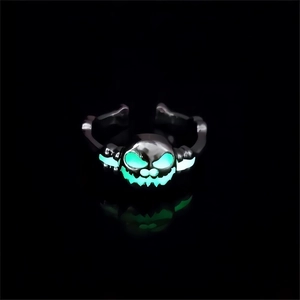 Detailed close-up of glow-in-the-dark pumpkin ring with green luminous eyes and mouth