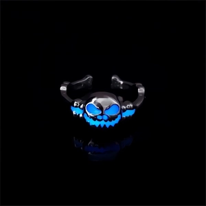 Macro shot of glow-in-the-dark Halloween skull ring with blue luminous eyes and mouth