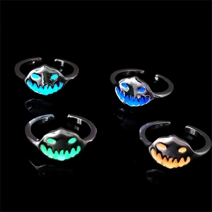 Detailed view of four glowing pumpkin rings in blue, green, and orange for Halloween