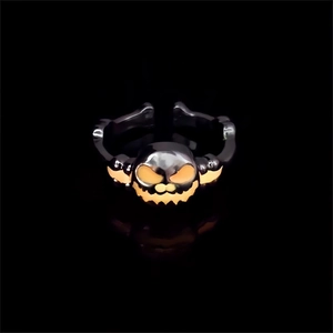 Macro shot of Halloween pumpkin skull ring featuring glowing orange eyes and adjustable band