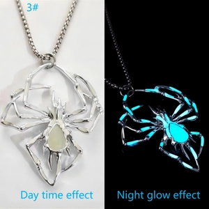 Détail du collier araignée argenté montrant son effet lumineux bleu dans l'obscurité