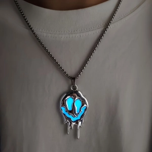 Gros plan du pendentif fantôme hip-hop avec lueur bleue lumineuse sur la chaîne
