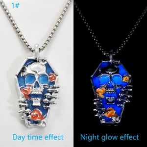 Luminous coffin pendant with skull and rose showing day and night glow effect