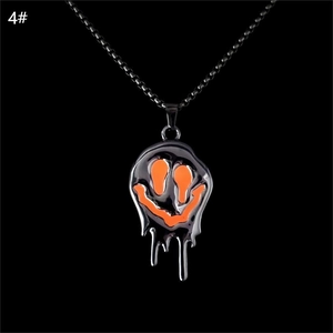 Gros plan détaillé du pendentif smiley noir de style lave avec des détails en émail orange