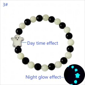 Close-up of Halloween ghost charm bracelet with glow in the dark beads on white background