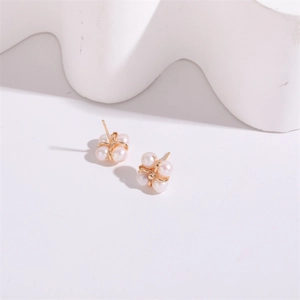 Detailed view of four-leaf clover stud earrings with 5mm freshwater pearls and gold base