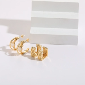 Detailed view of C-shaped gold chain earrings with cat-eye opal inlay on a white stand