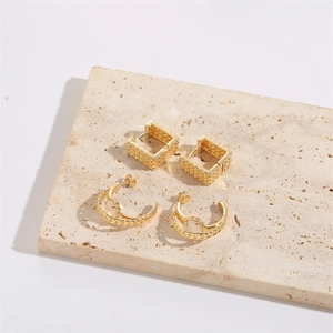 Golden cat eye C-shaped hoop earrings with woven texture and heart chain details