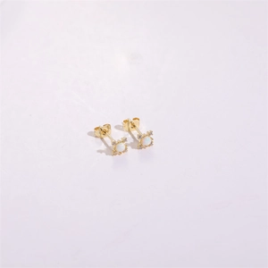 Macro shot of geometric star stud earrings with iridescent opal and zircon accents