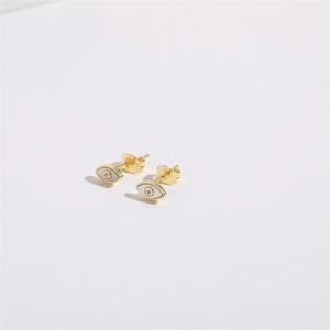 Macro side view of golden Evil Eye stud earrings with shell inlay and zircon center