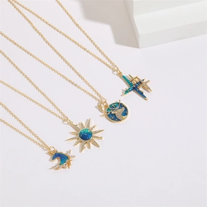 Detailed view of four gold-plated sun and unicorn pendants with blue-green enamel inlay