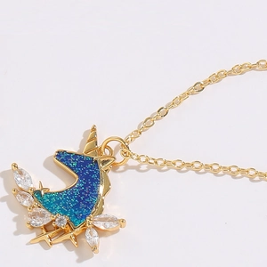 Close-up of golden unicorn pendant with blue-green glitter and marquise zircon stones