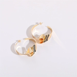 Close-up of golden irregular pleated hoop earrings with 14K gold polished finish