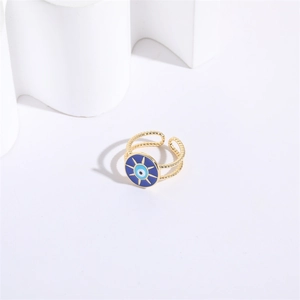 Détail macro d'une bague œil maléfique dorée avec émail bleu et anneau torsadé