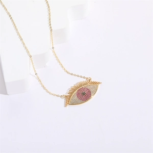 Gold-plated Evil Eye necklace with pink and black crystals on a white geometric stand