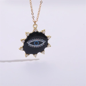 Collier doré avec pendentif soleil œil protecteur en émail noir et perles blanches