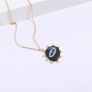 Collier doré œil protecteur avec pendentif soleil et cœur sur socle blanc