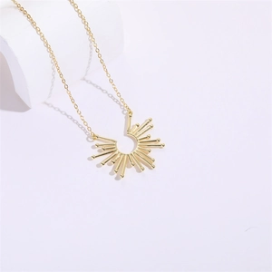 Gedetailleerde close-up van een gouden zonnestraal hanger aan een minimalistische ketting