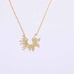 Macro detail van de gouden ketting met een zonnestraal hanger in een minimalistisch design