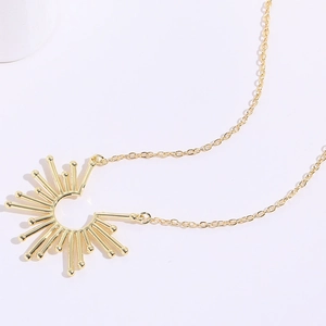 Gouden zonnestraal hanger ketting met stralende staafjes en kralen aan een fijne ketting