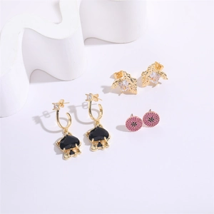 Close-up of gold hoop earrings with black heart charms and sparkling zircon stud details
