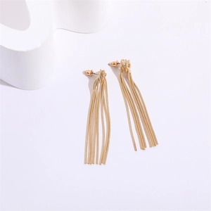 Macro shot of gold snake bone chain tassel earrings with smooth metallic luster