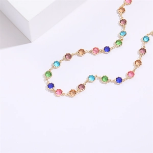 Collana girocollo in oro 14K con gemme colorate e base a fiore su sfondo bianco