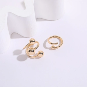 Anello a spirale dorato minimalista con sfere di metallo lucido su sfondo geometrico