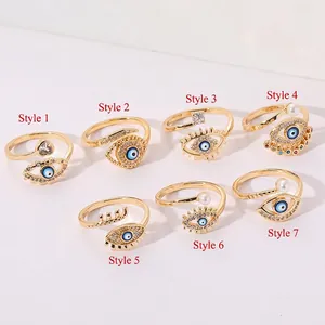 Set of seven gold plated evil eye rings with blue zircon, pearls and open bands