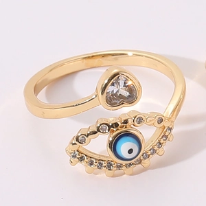Detailed close-up of a gold adjustable evil eye ring with pearl and heart zircon