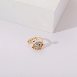 Gold evil eye open ring with pearl and multicolored zircon on white geometric stand
