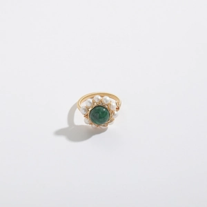 Detail of 14k gold wire wrapped ring with green gemstone and small white pearls