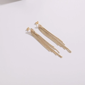 Close-up detail of 14k gold plated tassel earrings with sparkling rhinestone accents