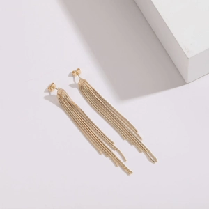Detail of long gold tassel earrings with multiple snake chains and shiny metallic finish