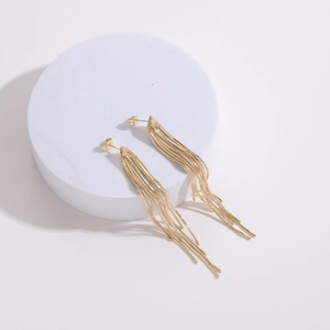 Detail view of 14k gold-plated tassel earrings with layered metal snake chains