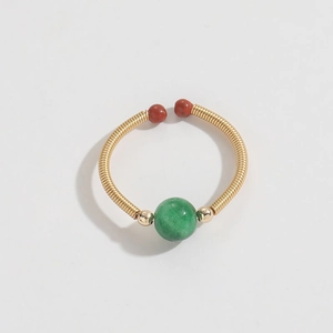 Detailed view of handmade copper wire ring with green gemstone and vintage beads
