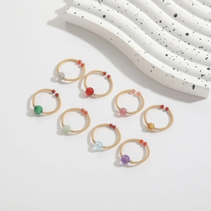 Detail of copper wire wrapped rings with natural gemstones in multiple colors