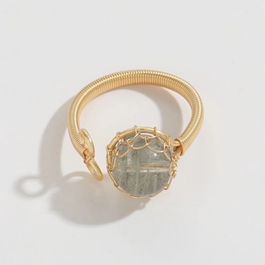 Detail of handmade 14k gold-wrapped wire ring with translucent green natural stone bead