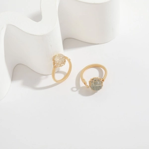 Detailed shot of handmade wire wrapped rings with natural quartz stones on white art props