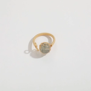 Detailed macro view of handmade gold wire wrapped ring with a round translucent gemstone