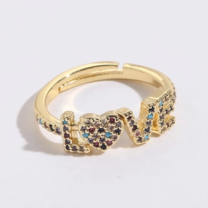 Détail macro de la bague ajustable dorée avec pierres en zircon colorées serties en coeur