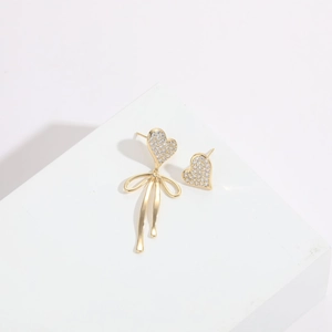 Macro shot of 14K gold plated heart earrings with pavé zircons and a bow detail