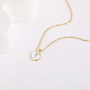 Golden necklace with a 14K gold plated rose flower pendant on a white enamel disc