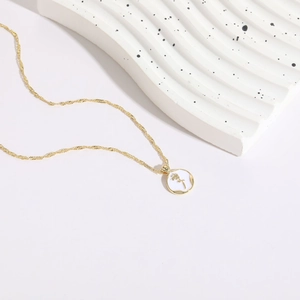 Detail showing white enamel rose coin pendant with 14K gold plated twisted rope chain