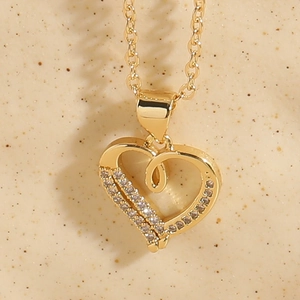 Detail of 14K gold plated heart pendant with zircon micro-paving and pearl accents