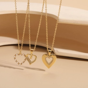 Detailed view of three 14K gold plated heart necklaces with pearls and zircon stones