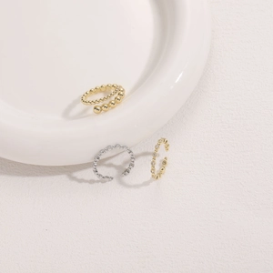 Minimalist 14K gold plated beaded band and zircon rings on a white ceramic tray
