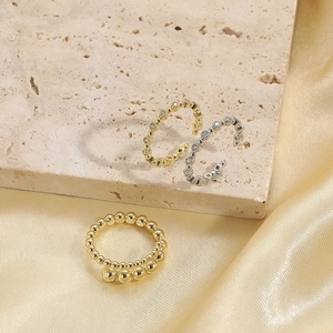Minimalist 14K gold plated beaded and zircon open wave rings on silk fabric background