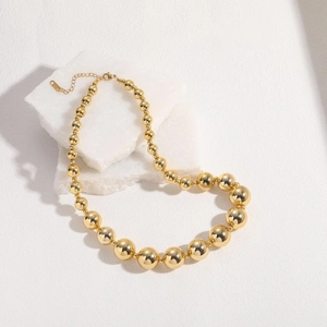 Detailed macro of 18K gold beaded necklace with gradient sphere sizes and lobster clasp