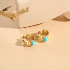 Detail of adjustable gold rings with turquoise stones and hammered relief patterns